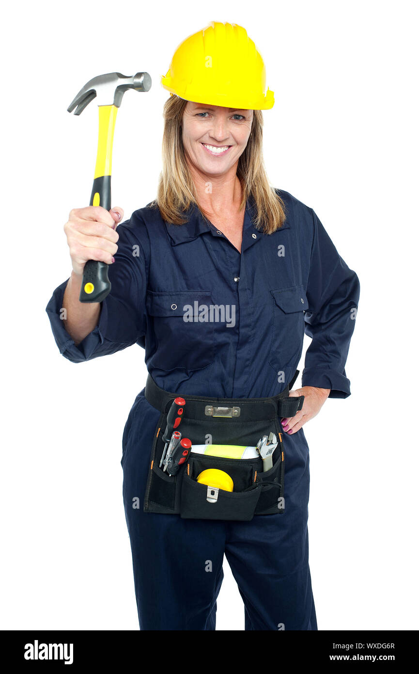 Construction Worker holding en uniforme jusqu'à inertie avec tool kit autour de sa taille. Banque D'Images