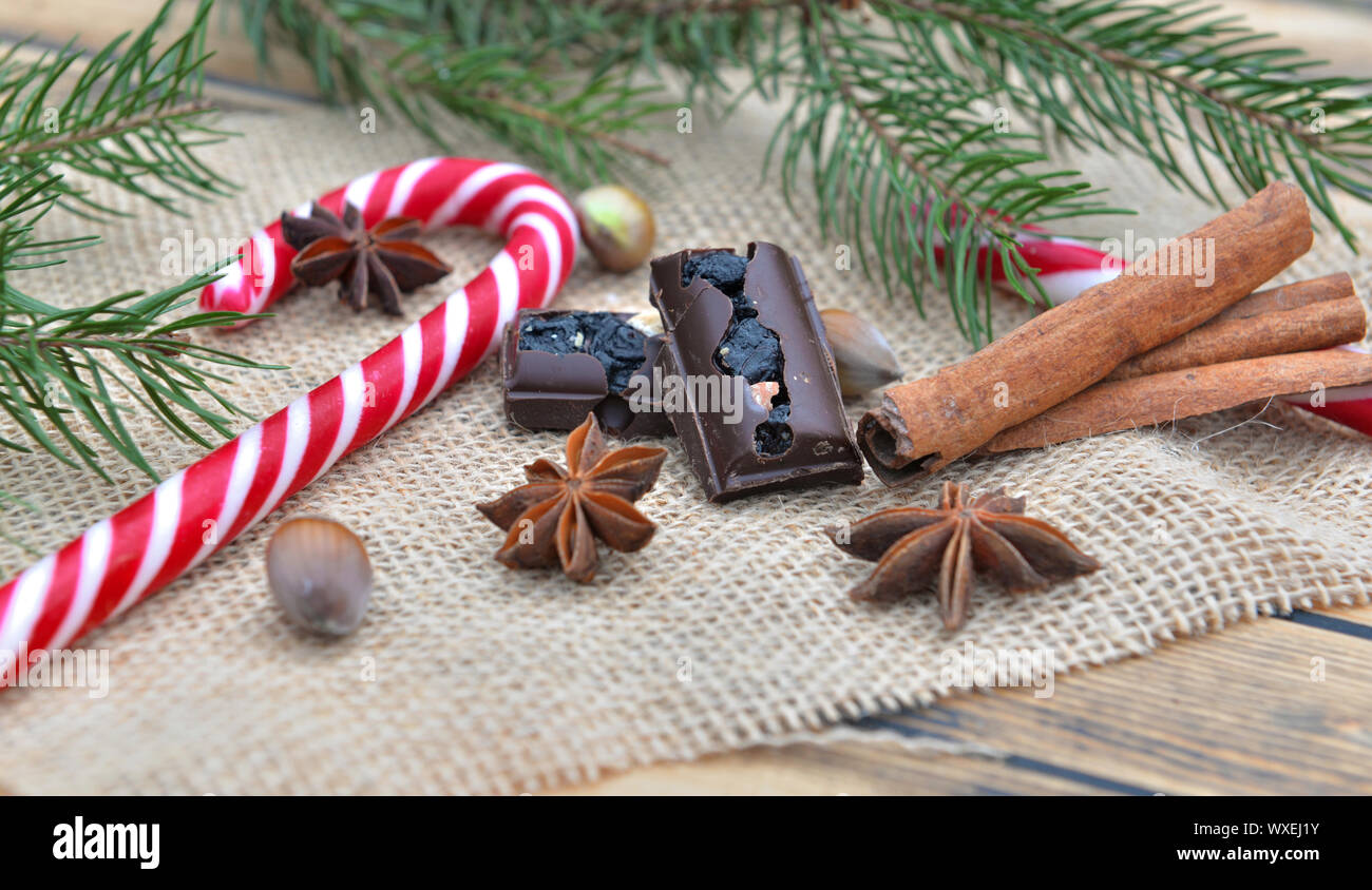 Des épices, des cannes de bonbon et chocolat mis sur une décoration de Noël en textil naturelles Banque D'Images
