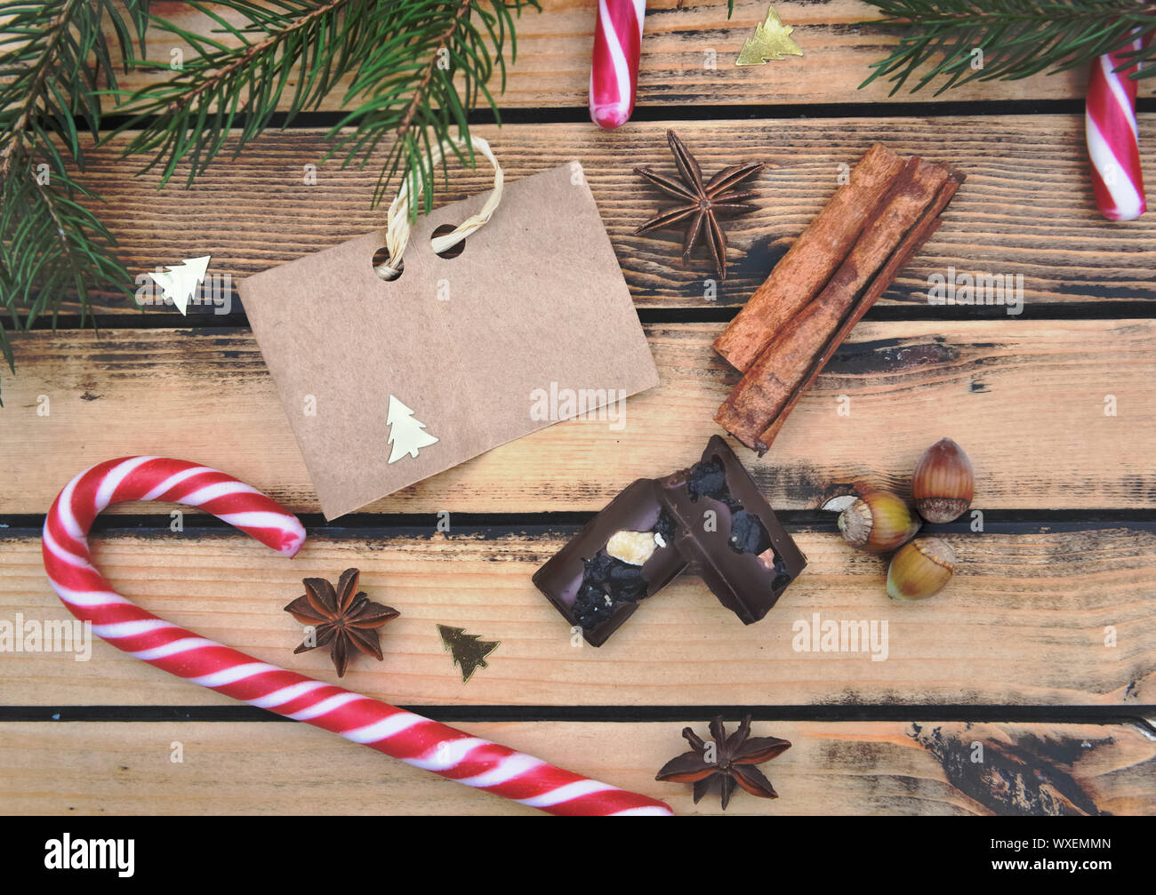 Peu de papier brun mis sur fond en bois rustique avec des épices des cannes de bonbon et chocolat Banque D'Images