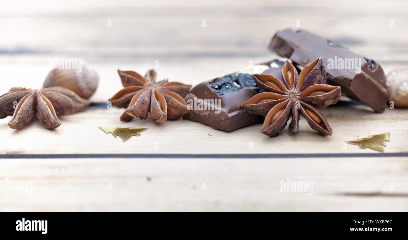 Près de l'anis étoilé avec chocolat et confettis christment sur fond de bois Banque D'Images