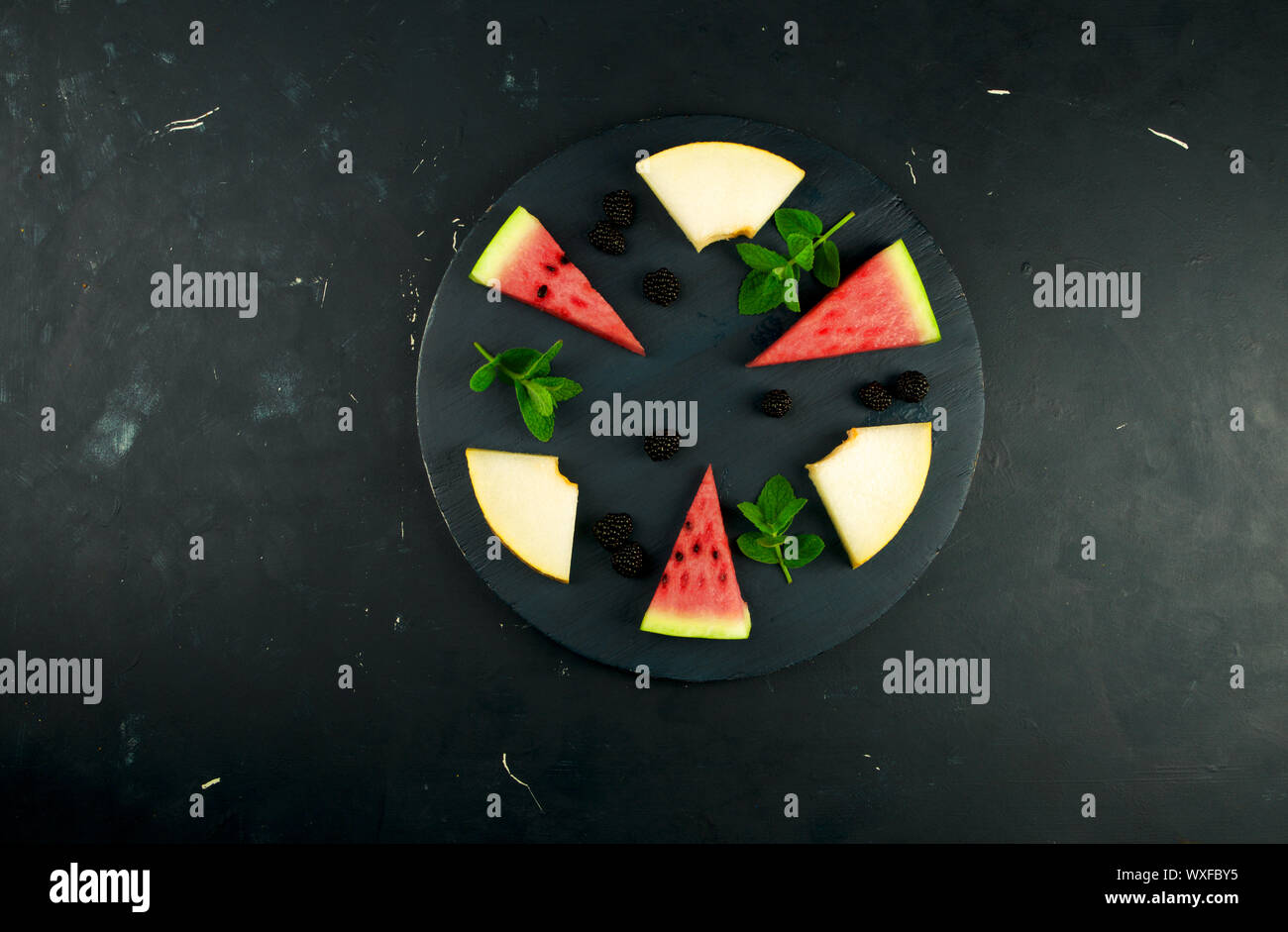 La pastèque MELON ET MENTHE BLACKBERRY SUR L'ARRIÈRE-PLAN. Trois MORCEAUX DE PASTÈQUE MELON mûr juteux avec des Mûres Mûres MINT Banque D'Images