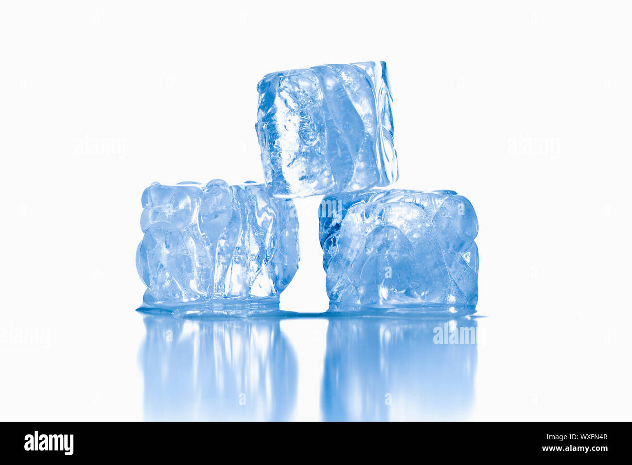 Des cubes de glace shot sur surface blanche réfléchissante Banque D'Images