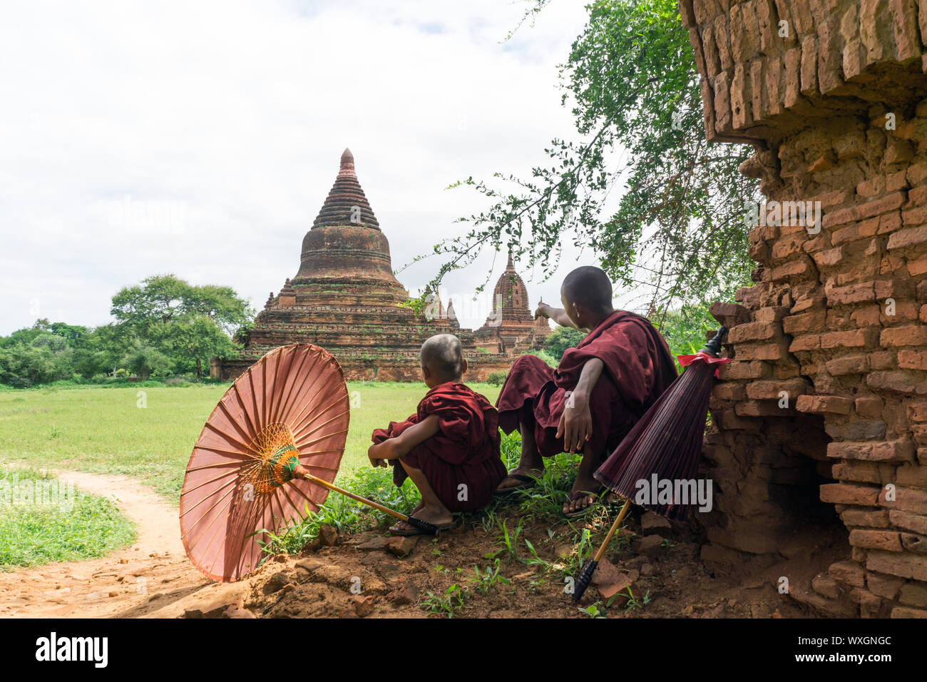 Les moines bouddhistes se reposer et admirer un ancien temple à Old Bagan, Myanmar Banque D'Images