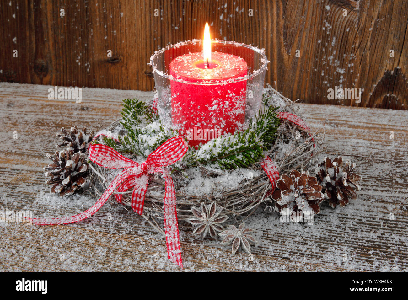 Naturelle décoration de Noël : une bougie rouge dans une lanterne entouré  d'une couronne de brindilles sur une planche en bois Photo Stock - Alamy