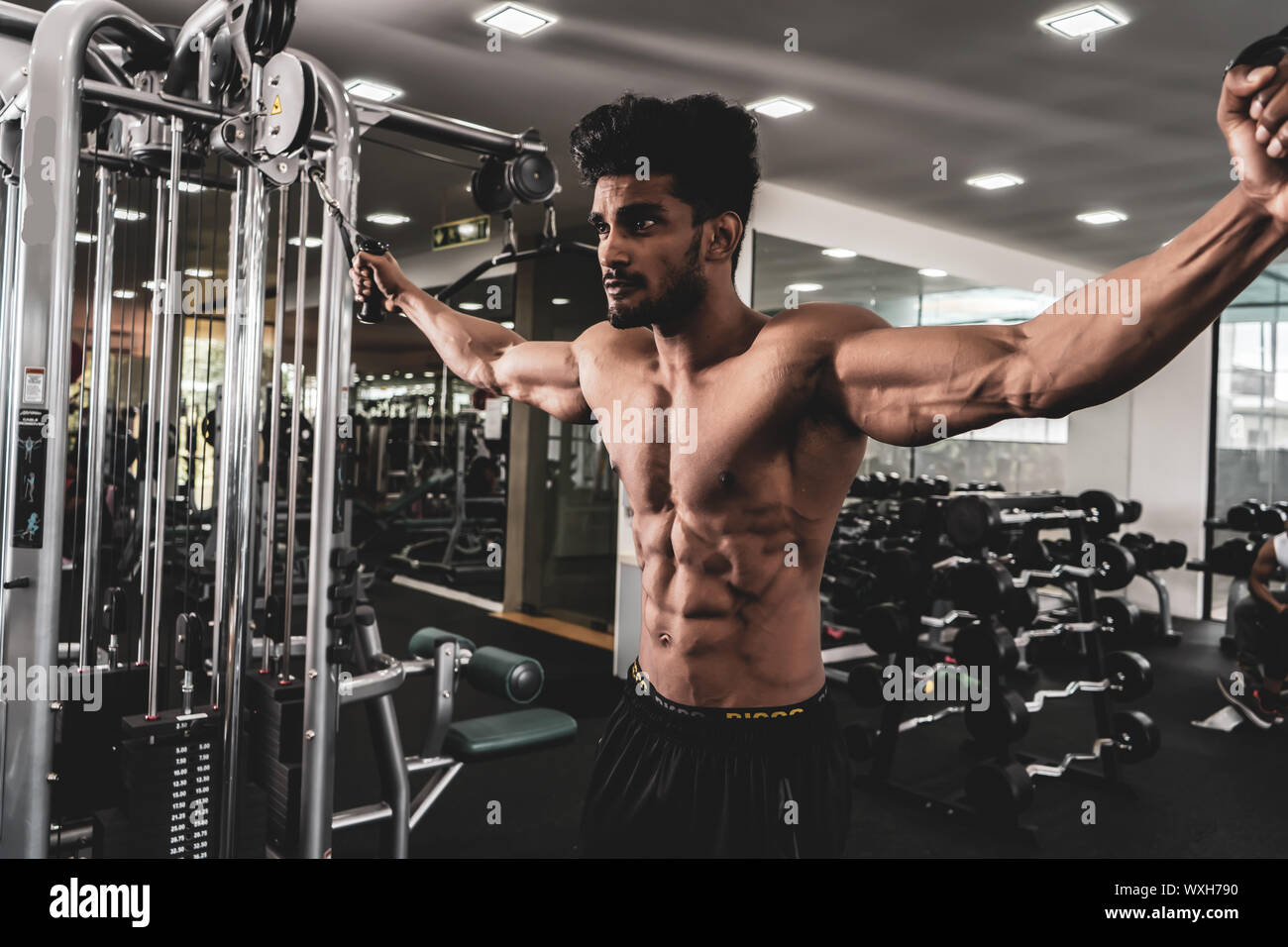 Bodybuilder travaille sur sa poitrine avec Cable Crossover dans une salle de sport. Crier pour la motivation Banque D'Images