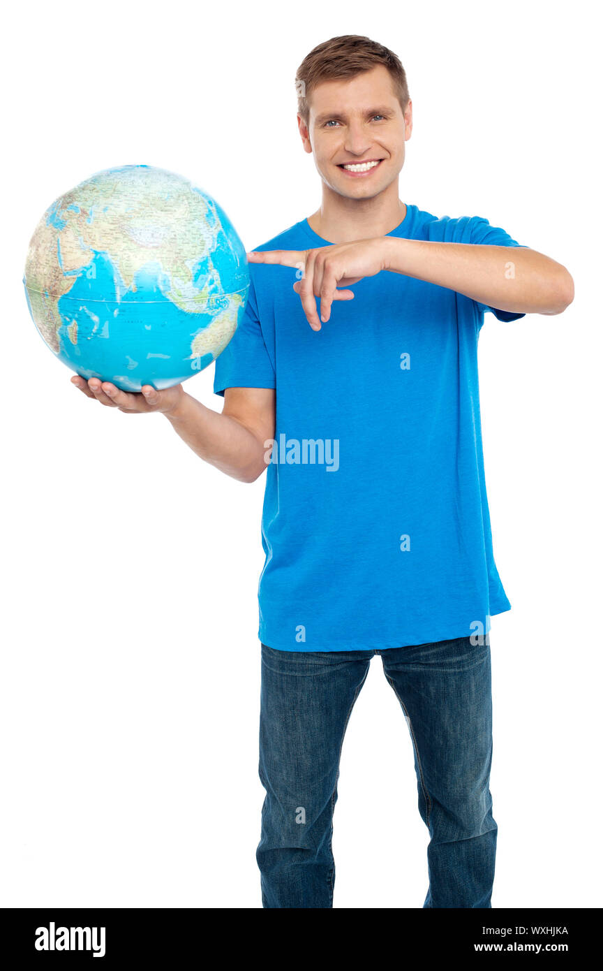 Smart Guy pointing au globe. Vêtu d'occasionnels. Isolated over white Banque D'Images