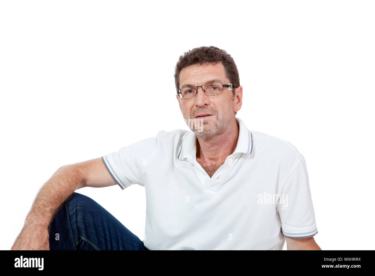 L'homme adulte en bonne santé attrayants assis sur le plancher avec un jean isolated Banque D'Images