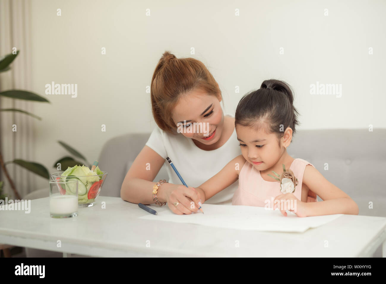 La famille asiatique avec la mère et les filles sont dessin sur le papier à la maison. Banque D'Images