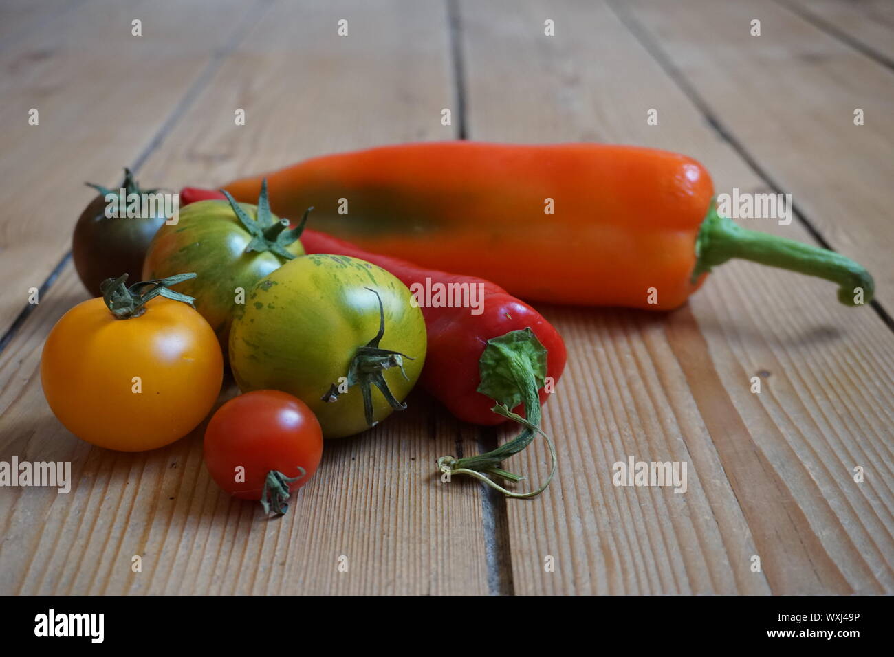 Ensemble de longue multicolore de poivrons et tomates heirloom sur une table en bois rustique Banque D'Images