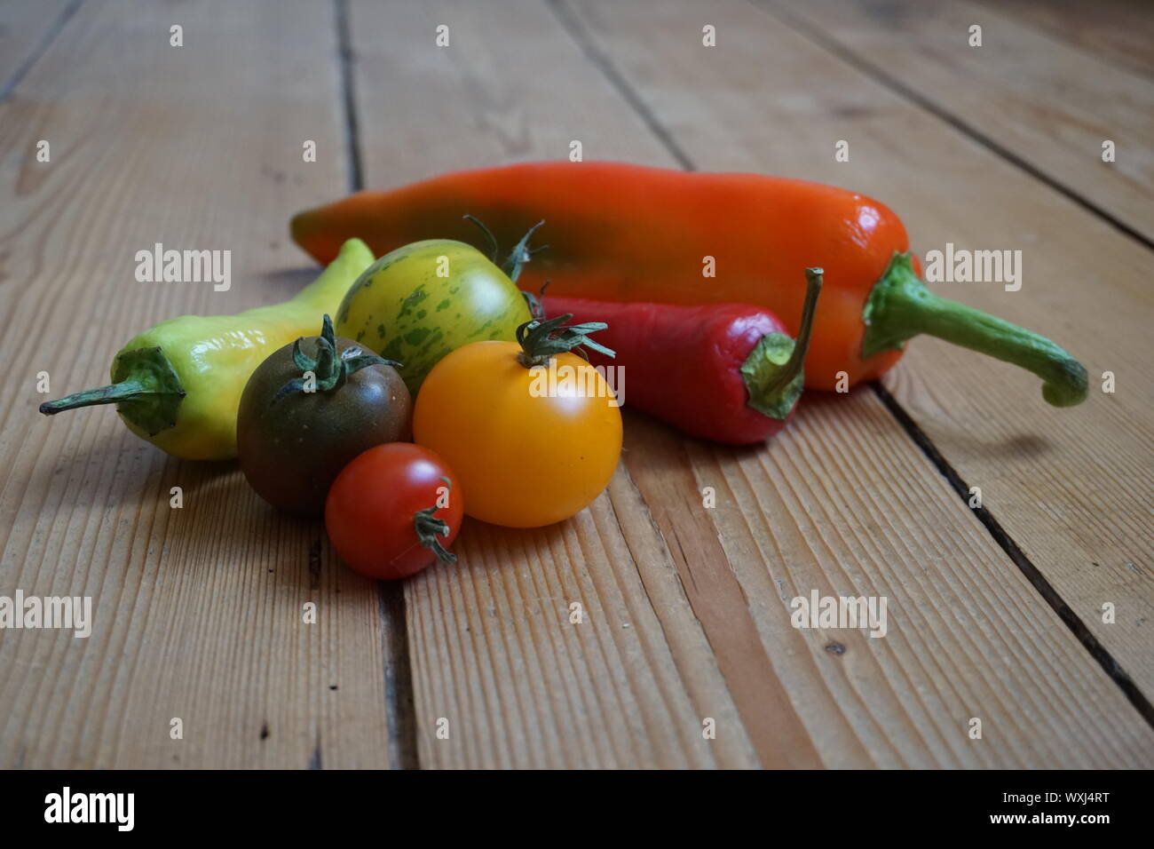 Ensemble de longue multicolore de poivrons et tomates heirloom sur une table en bois rustique Banque D'Images