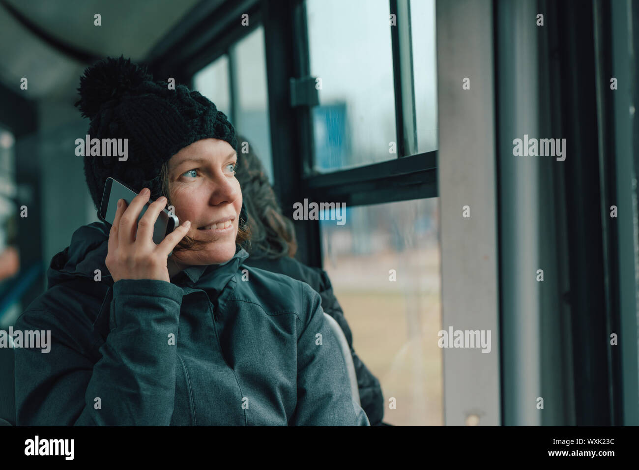 Belle hot Woman talking on mobile phone dans les bus dans l'après-midi d'hiver froid Banque D'Images