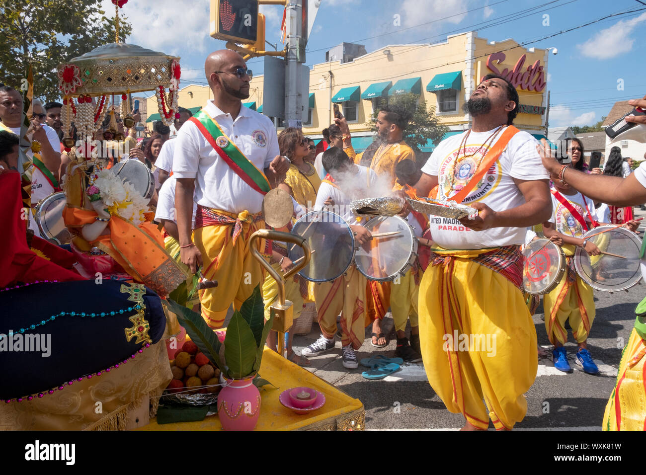 Au début de la Parade de Madrassi pour l'unité dans la communauté, un homme hindou dévot effectue le rituel arti devant statue de Ganesh. Dans le Queens, New York. Banque D'Images