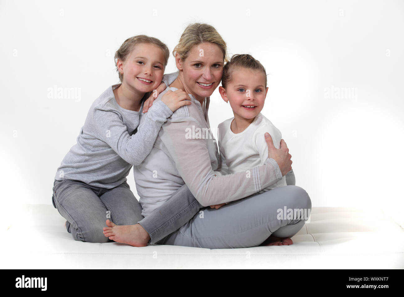 Mère embrassant ses deux petites filles Banque D'Images