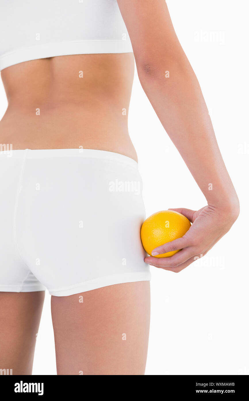 Toned female buttocks with orange on part sur fond blanc Banque D'Images