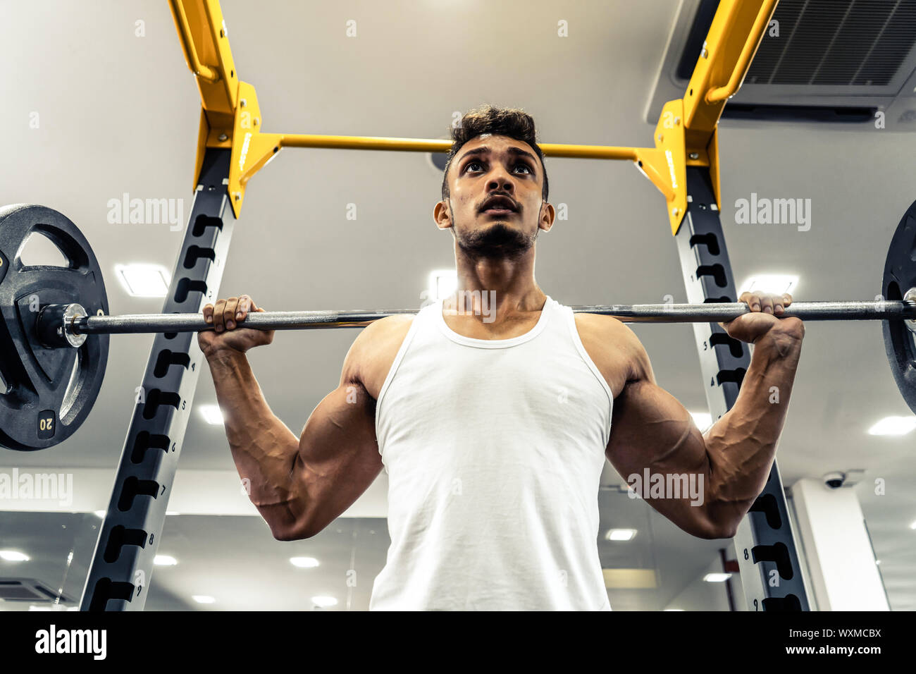 L'homme dans la salle de sport. Exécuter l'exercice accroupi avec le poids, dans la salle de sport Banque D'Images