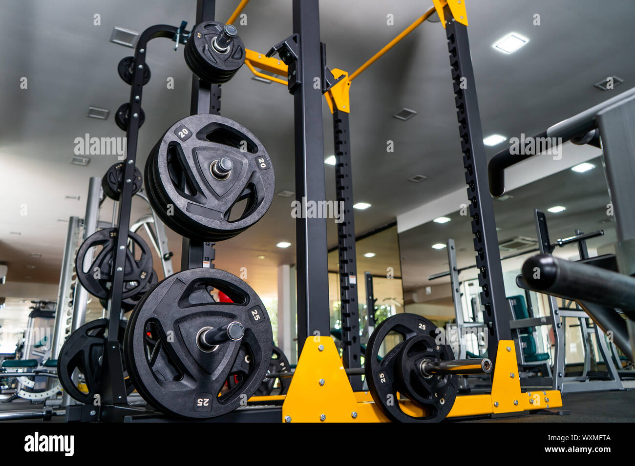 Moderne salle de sport. Les appareils de sport en salle de sport. Barres de différents poids sur rack. Banque D'Images