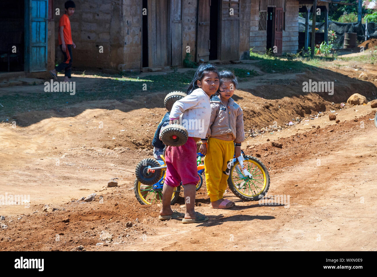 Pakse, Laos - Dec 2016 : Groupe de jeunes filles jouant avec location à côté de la route dans le village Laotien Banque D'Images