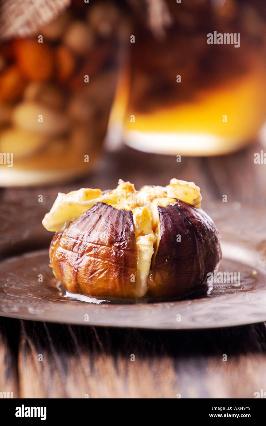 Figues mûres gratiné au fromage de lait de vache et de brie camambert et saupoudrée de chapelure sur vintage cooper plaque. Pots de miel avec nuta sur toile Banque D'Images