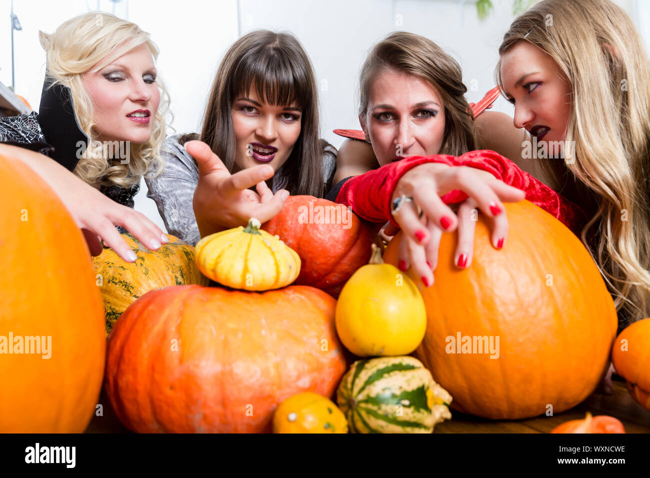 Trois jeunes et belles femmes portant des costumes bon marché tout en agissant comme des sorcières se joindre à leurs forces malveillantes à l'Halloween Banque D'Images