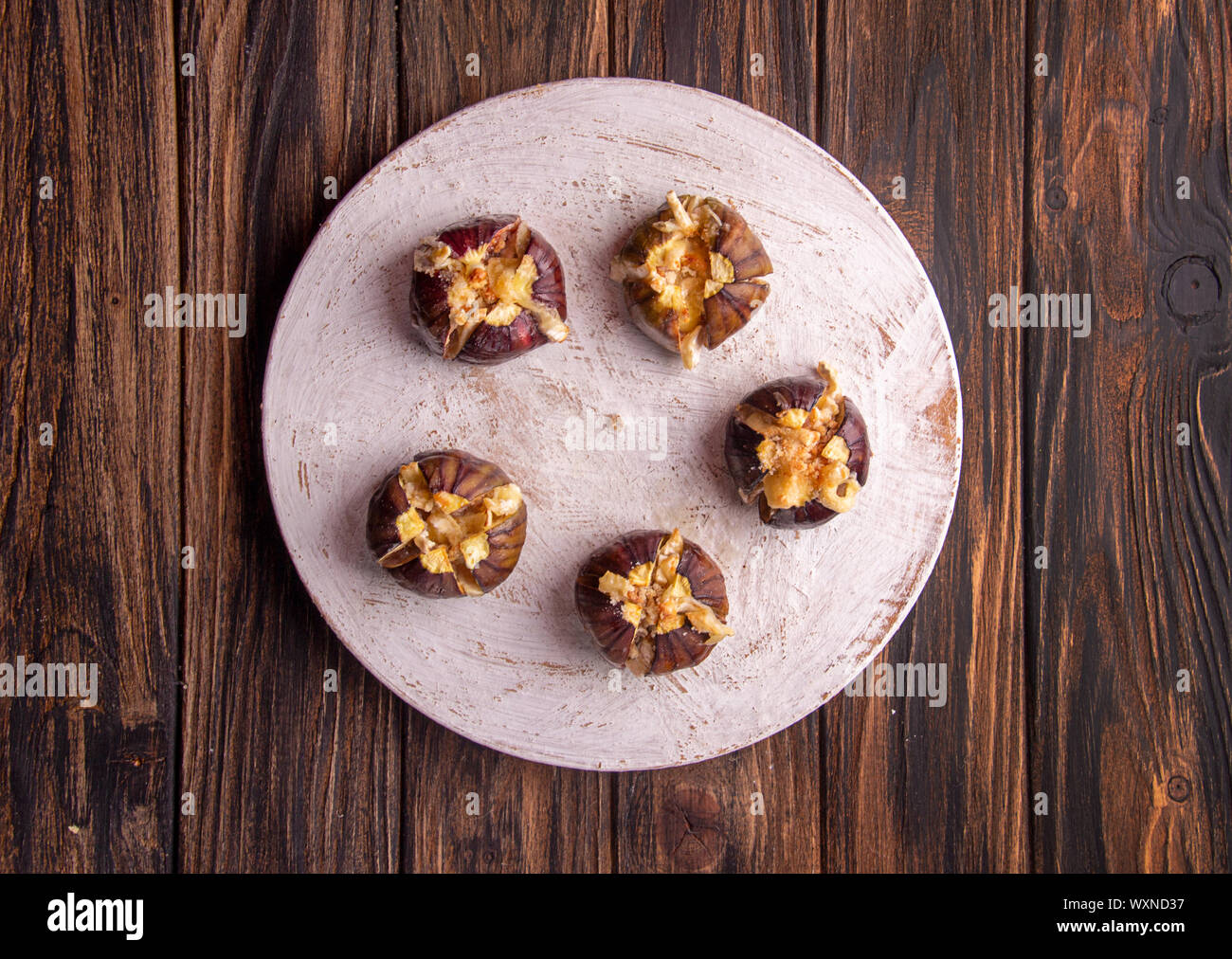 Figues mûres gratiné au fromage de lait de vache et de brie camambert et saupoudré de miettes de pain décoré de feuilles de menthe sur fond de bois. Ée en bonne santé Banque D'Images