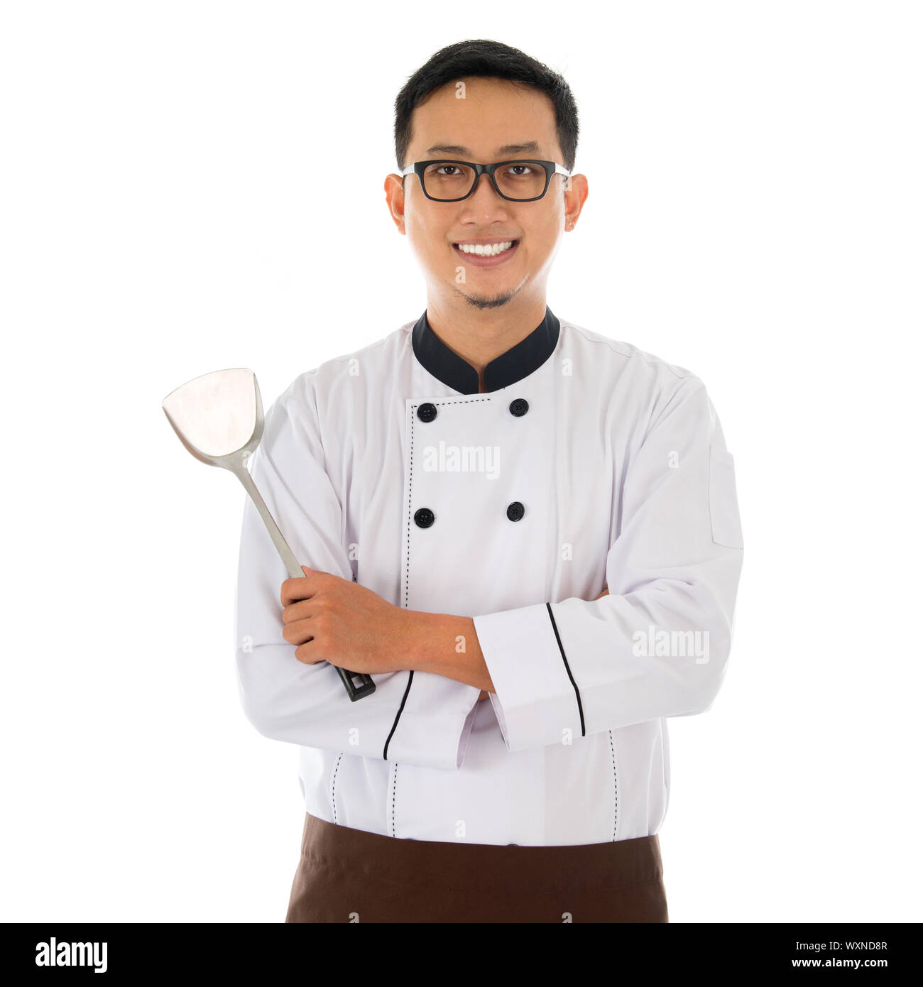 Portrait of Asian chef holding spatule, kissing isolé sur fond blanc. Banque D'Images