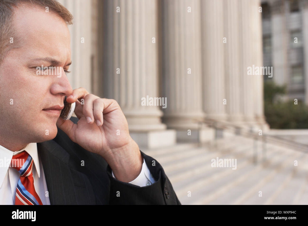 Serious businessman using cell phone in front of building Banque D'Images