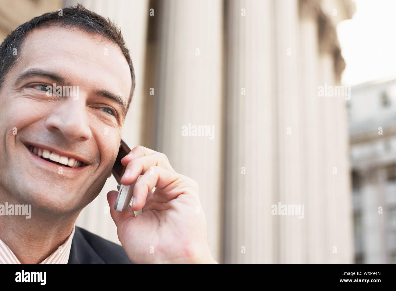 Gros plan du happy businessman using cell phone outdoors Banque D'Images