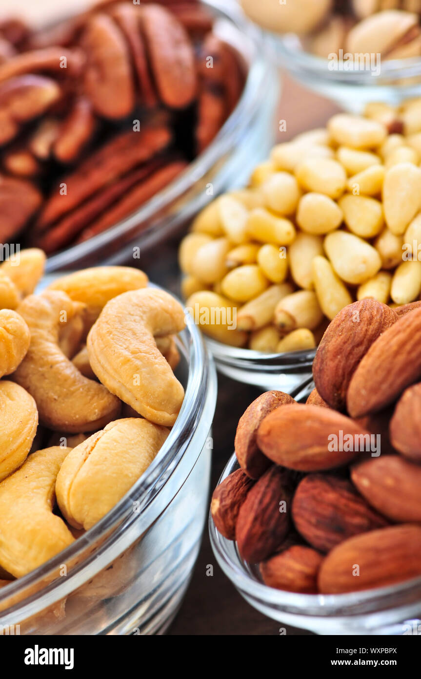 Amandes, pistaches, noix de cajou et les noix de pin dans des bols en verre Banque D'Images