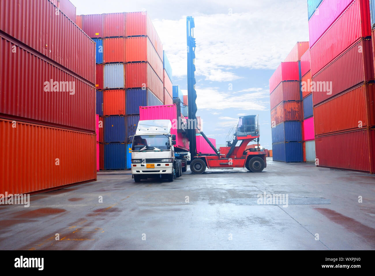 Chariot élévateur dans l'expédition de conteneurs de fret de levage ou de cour de triage dock contre lever du soleil Ciel avec pile de conteneurs de fret en arrière-plan pour le transport je Banque D'Images