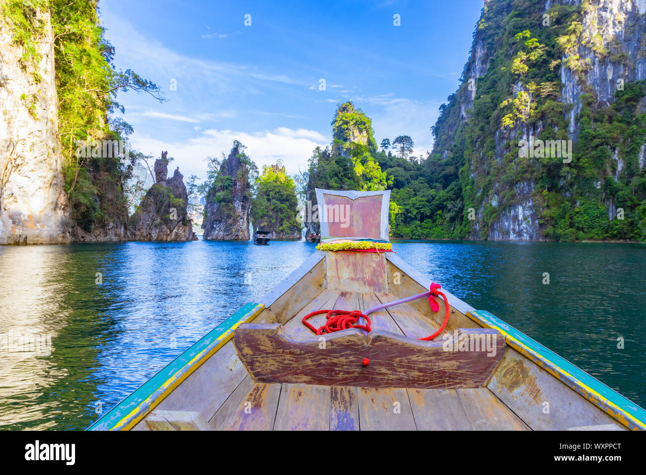 Bateau en bois sur la voile à Ratchaprapa Dam et le lac Cheow Larn Khao Sok, la nature belle en Thaïlande Banque D'Images