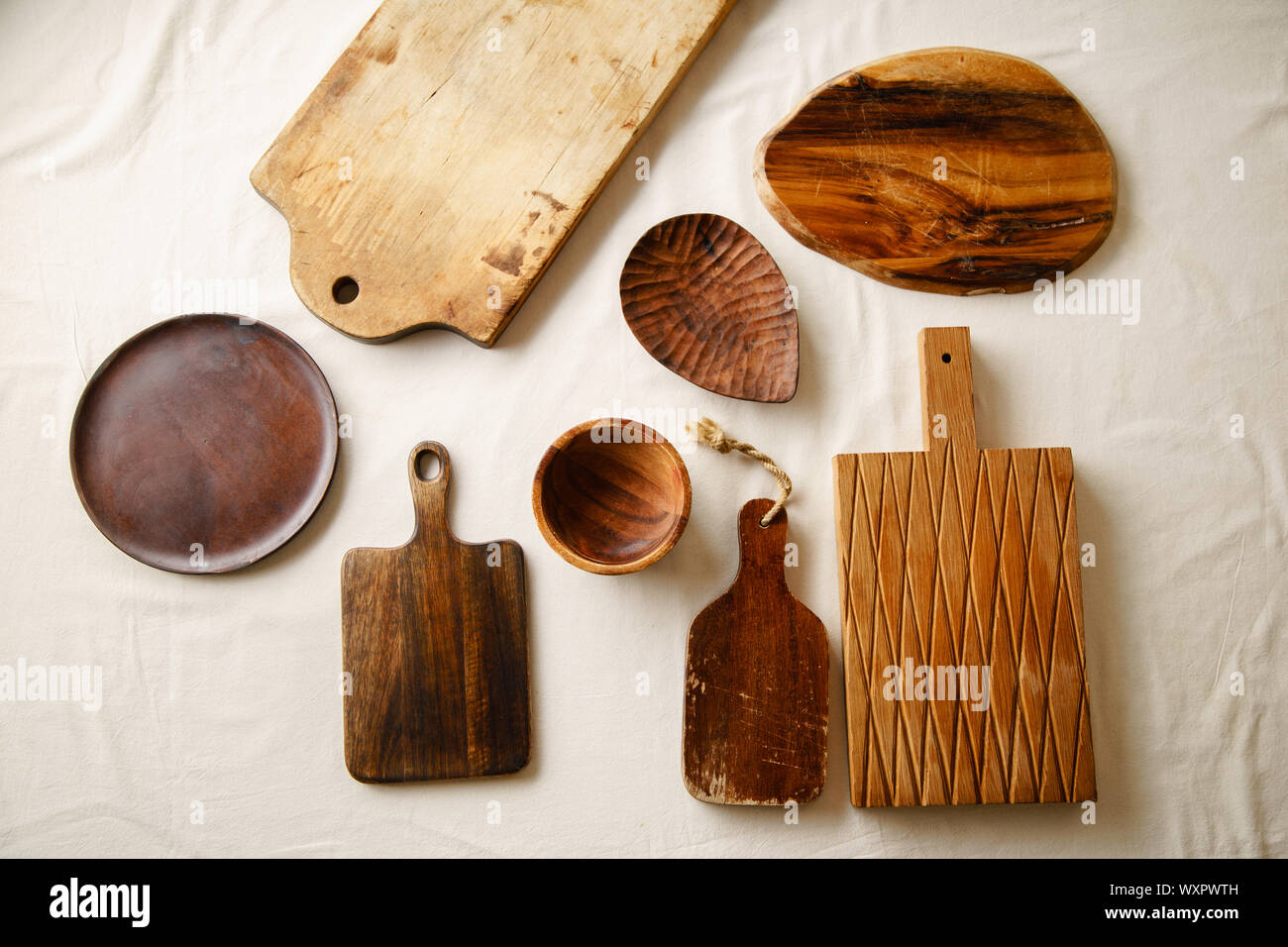 Divers vaisselle en bois. Les planches à découper, la plaque et le bol sur lin cirée Banque D'Images