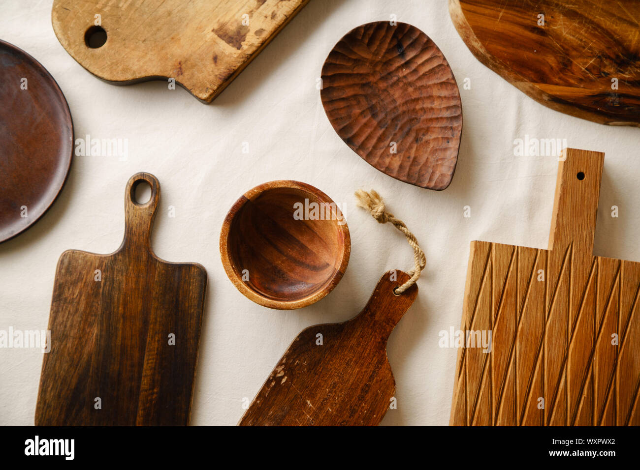 Divers vaisselle en bois. Les planches à découper, la plaque et le bol sur lin cirée Banque D'Images