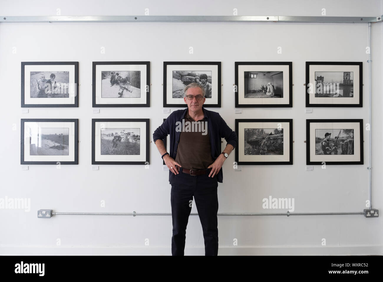 Craig Wallace rédacteur de Sogo Arts magazine dans la galerie Arts Sogo sur Saltmarket à Glasgow, Écosse, Royaume-Uni. Exposition de photographies de guerre par David Pratt exposition en cours. Banque D'Images