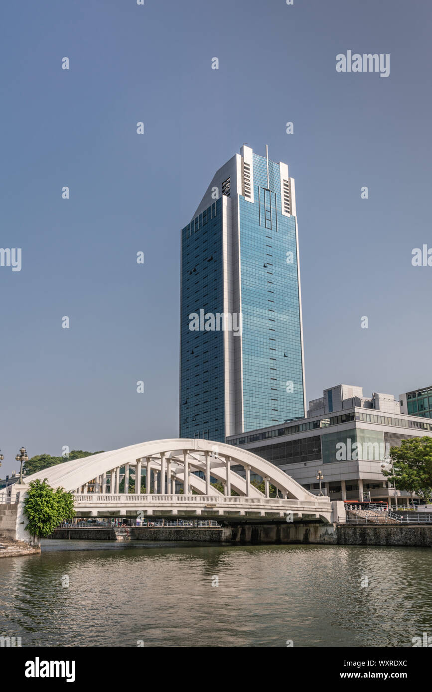 Singapour - Mars 21, 2019 : le long de la rivière Singapour. Pont Elgin avec de grandes vacances et d'une tour à bureau adjacent au centre d'affaires dans le cadre de ciel bleu. Arbres Banque D'Images