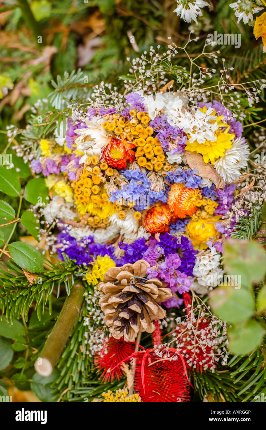 Bouquet de fleurs colorées au cours de Christian Toussaint cas couché dans la tombe dans le cimetière Banque D'Images