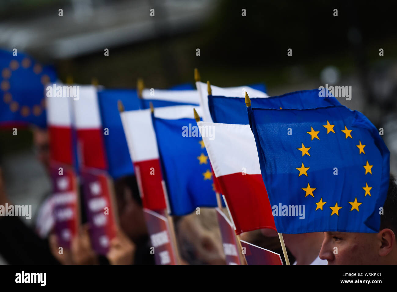 L'Union européenne et les drapeaux polonais sont considérés comme le chef de l'aile gauche Razem parti et l'un des dirigeants de l'alliance de gauche, la gauche (Lewica) Adrian Zandberg parle lors d'une conférence de presse à venir de la Pologne de se présenter aux élections parlementaires en face de château de Wawel. Banque D'Images