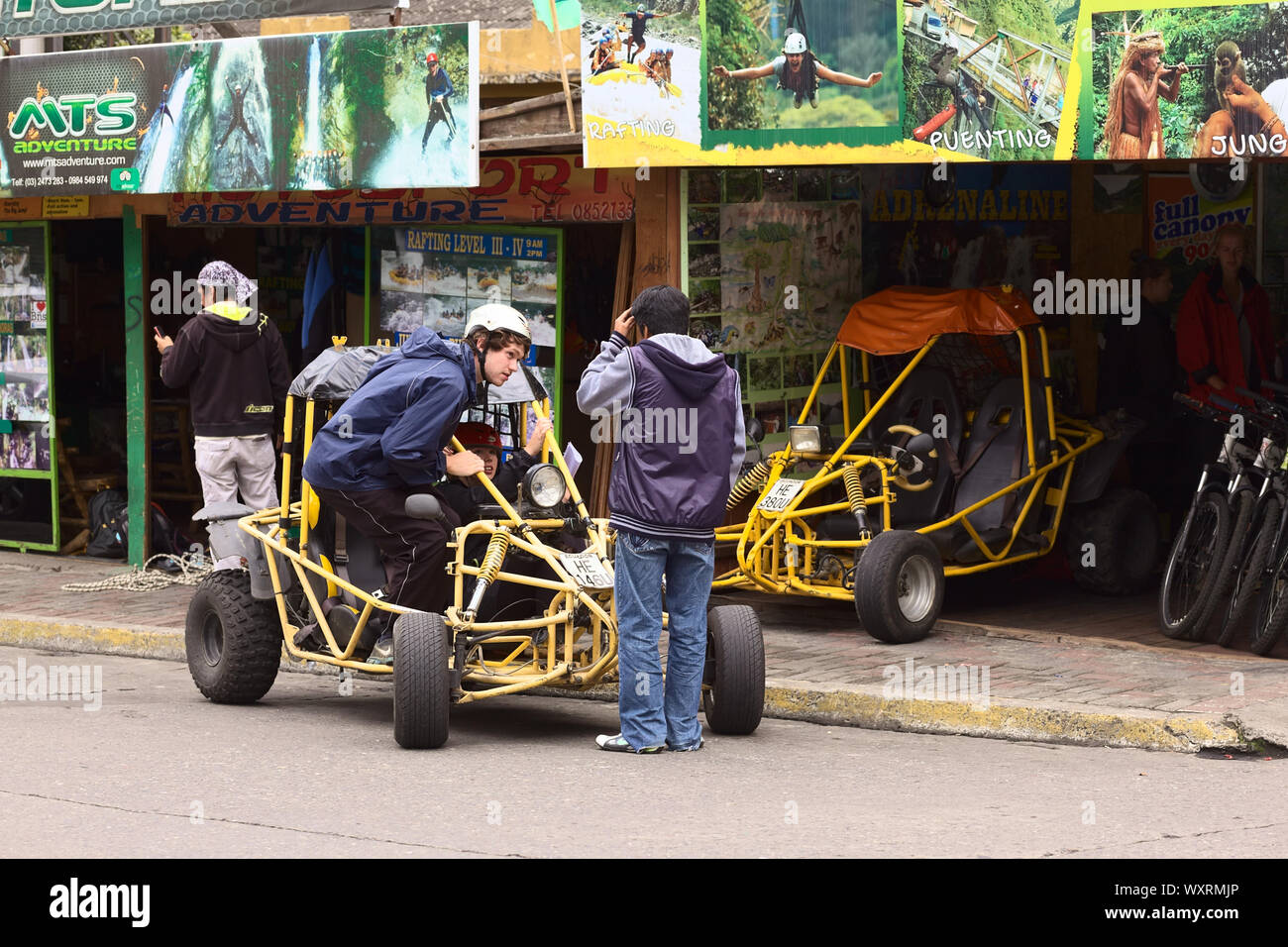 BANO, EQUATEUR - 25 FÉVRIER 2014 : personnes non identifiées dans et à une poussette devant un tour-opérateur et location de véhicule sur 16 rue de Diciembre Banque D'Images