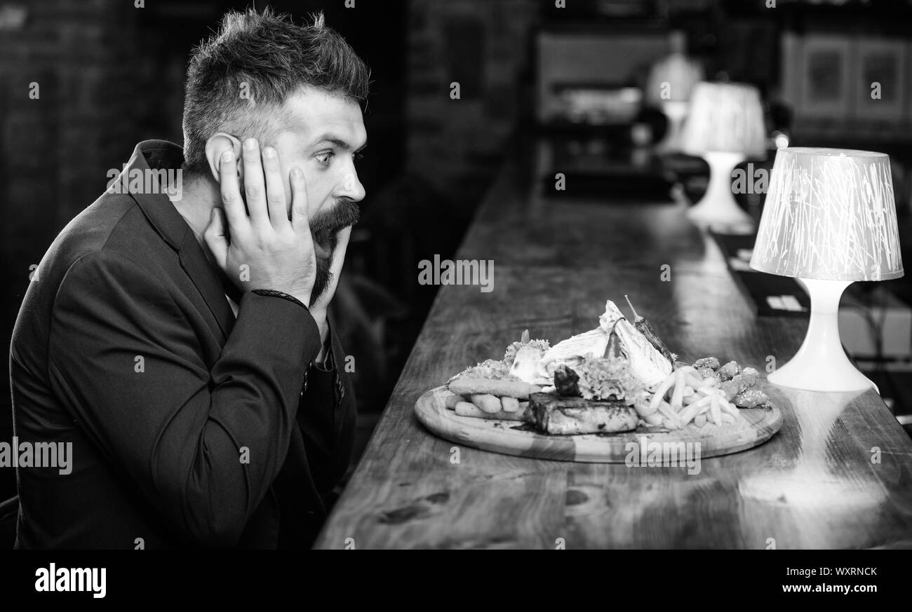 Des calories. Vous pourrez vous détendre après une dure journée de travail. Woman costume formel s'asseoir à comptoir bar. L'homme a reçu de pommes de terre frites repas avec viande et poisson, lavash. Il méritent de délicieux repas. Profitez de repas. Banque D'Images