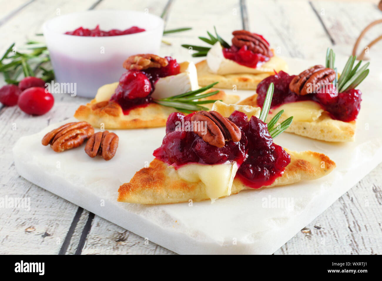 Maison de pain plat hors-d avec des canneberges, pacanes et fromage brie. Close up scène table sur un plateau blanc. Banque D'Images