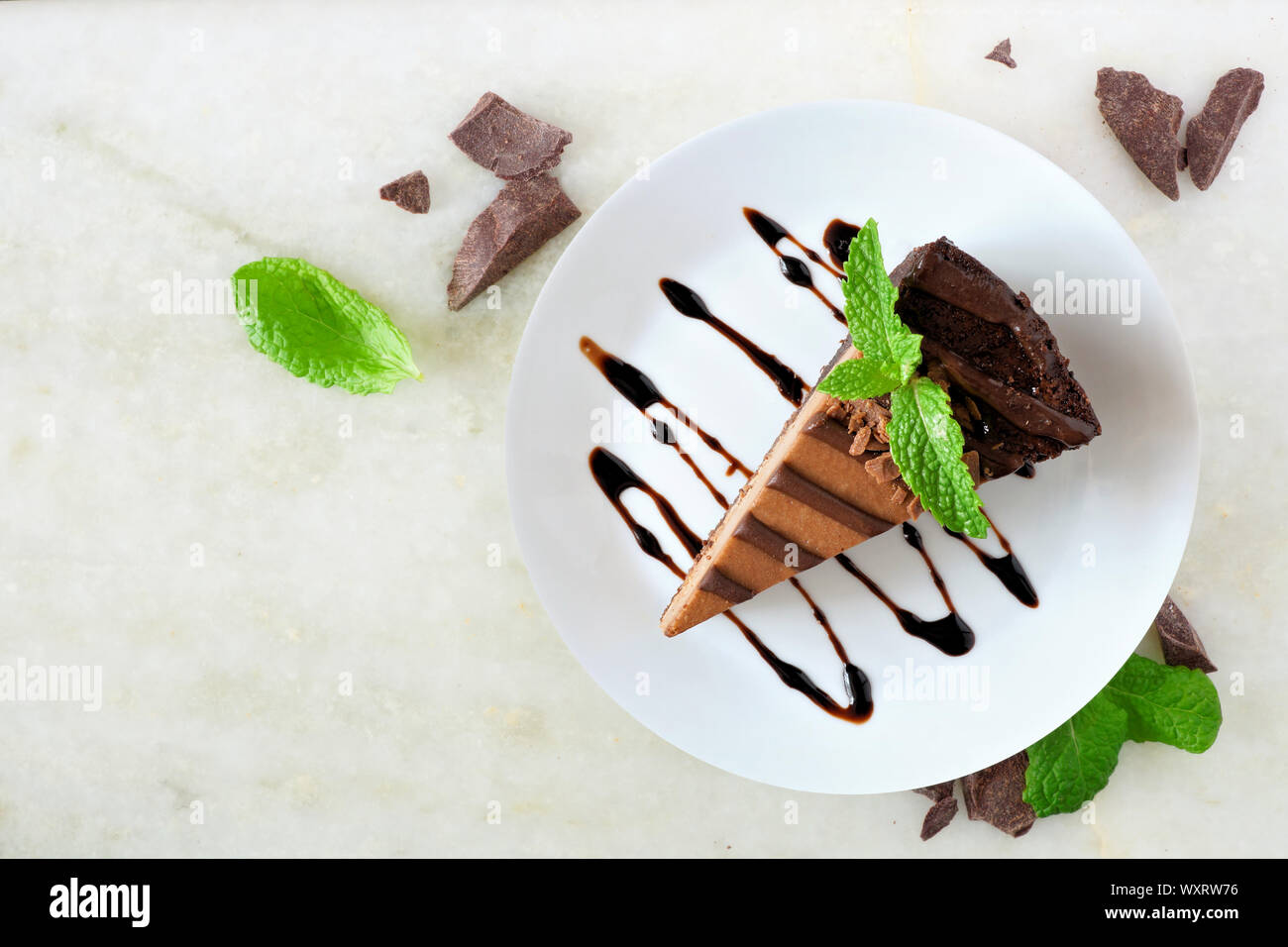 Tranche de gâteau au fromage au chocolat sur la plaque, au-dessus sur un fond noir en blanc Banque D'Images