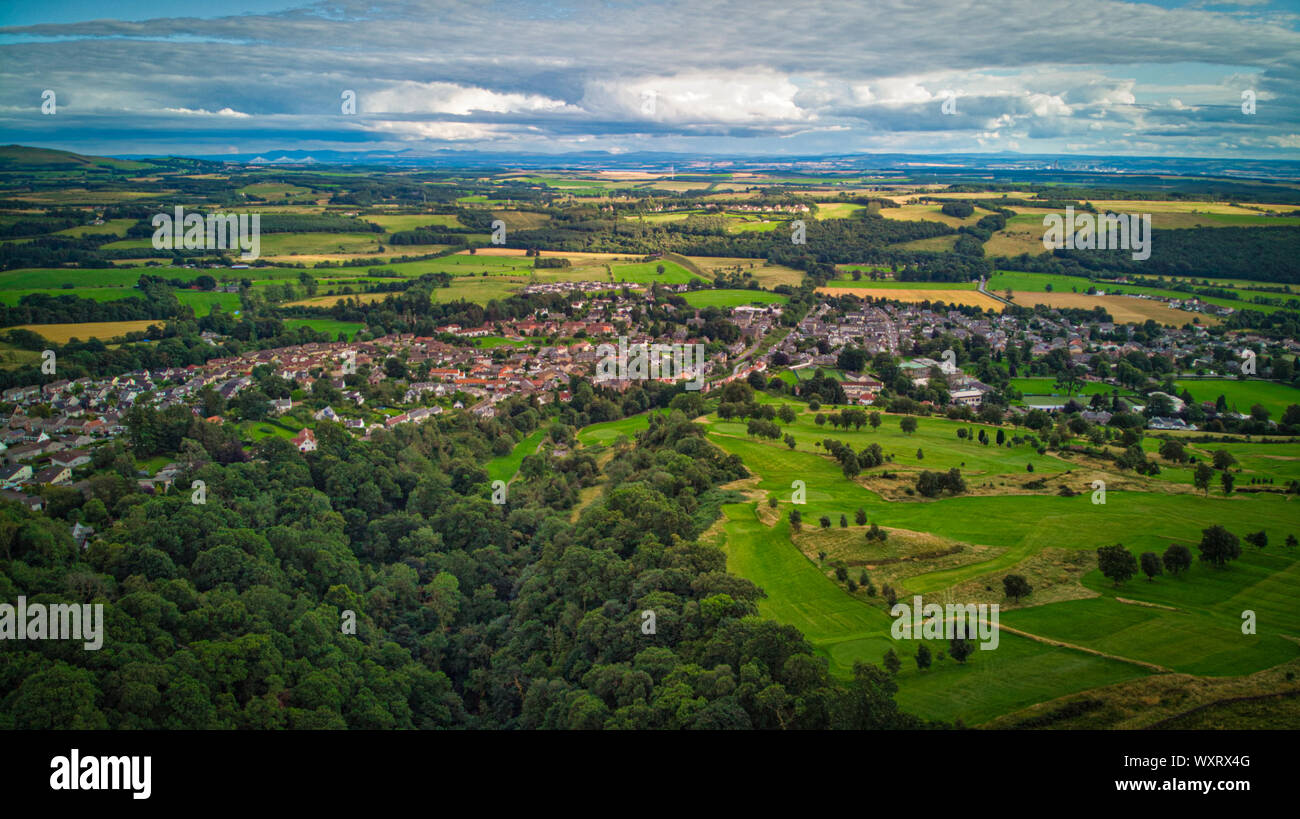 Village rural au milieu de champs verts et de bois, sous un ciel nuageux Banque D'Images