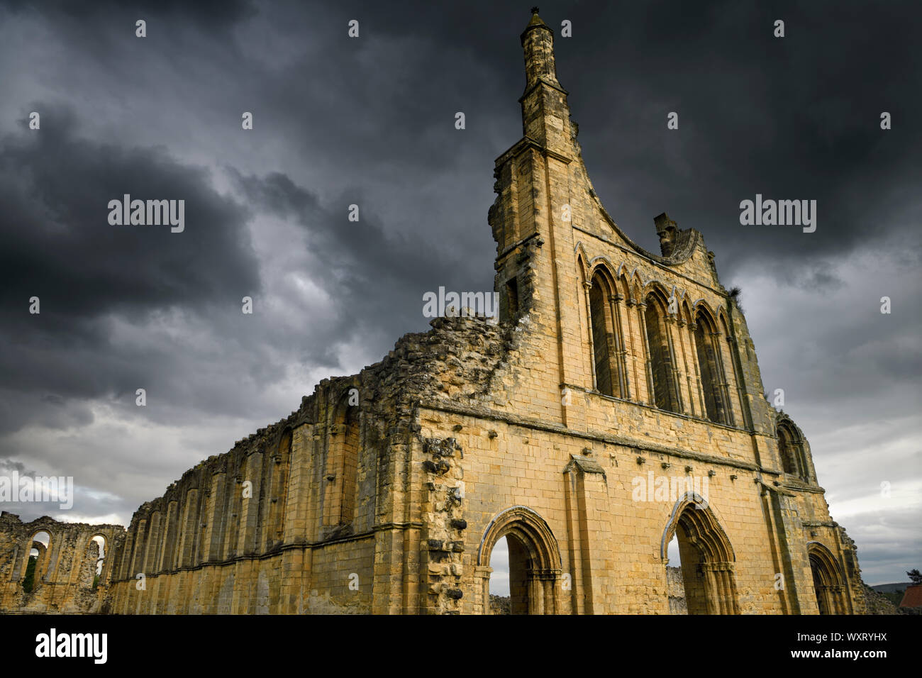 Grande église médiévale ruines de Byland Abbey North Yorkshire Angleterre avec dark storm clouds at sunset Banque D'Images