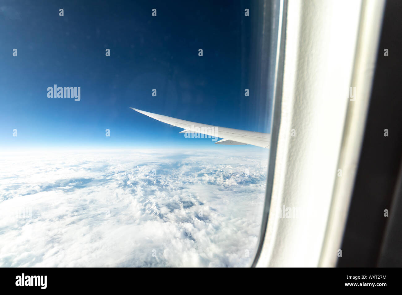 Vue sur une fenêtre Boeing 787 tout en survolant des montagnes enneigées. Banque D'Images