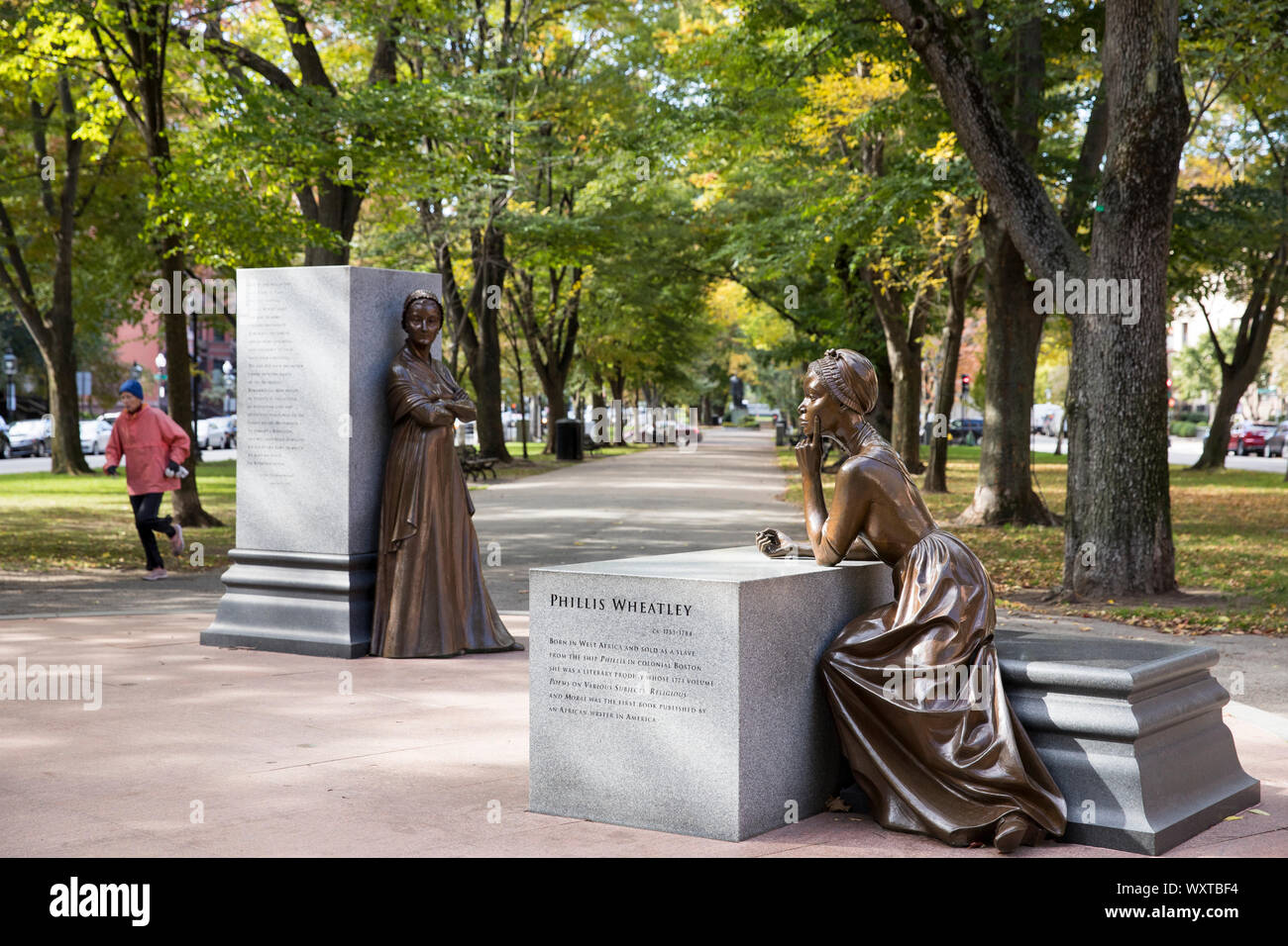Jogger par des statues de Phillis Wheatley et Abigail à Adamis Boston Women's Memorial de Commonwealth Avenue Mall, Boston, États-Unis Banque D'Images