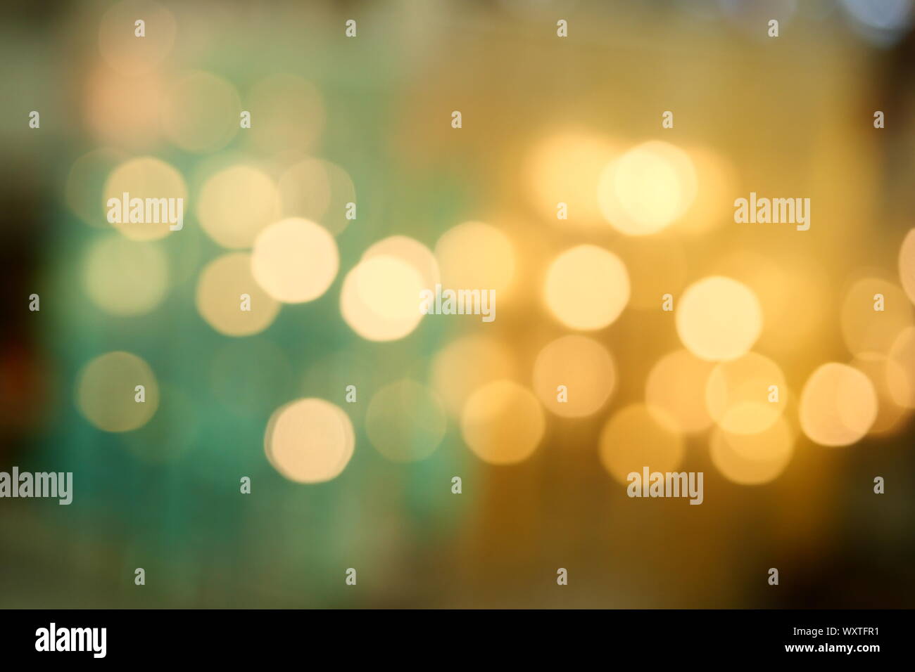 Bokeh à partir de l'éclairage intérieur, les cercles de lumière colorés répartis sur bleu avec fond jaune et vert pour la célébration de la saison de vacances Banque D'Images
