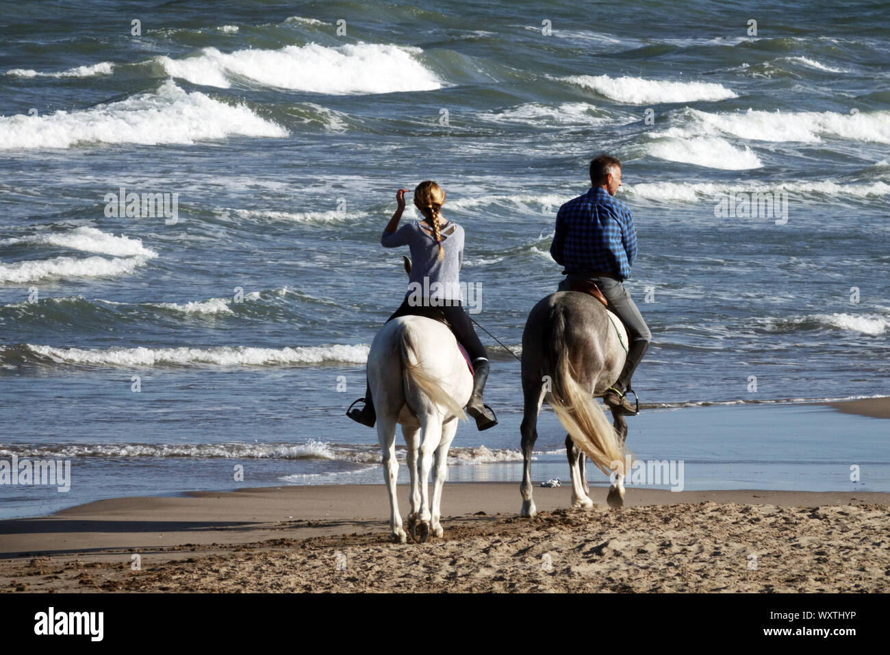 Les gens des cavaliers, des chevaux de couple sur une plage, Espagne Banque D'Images