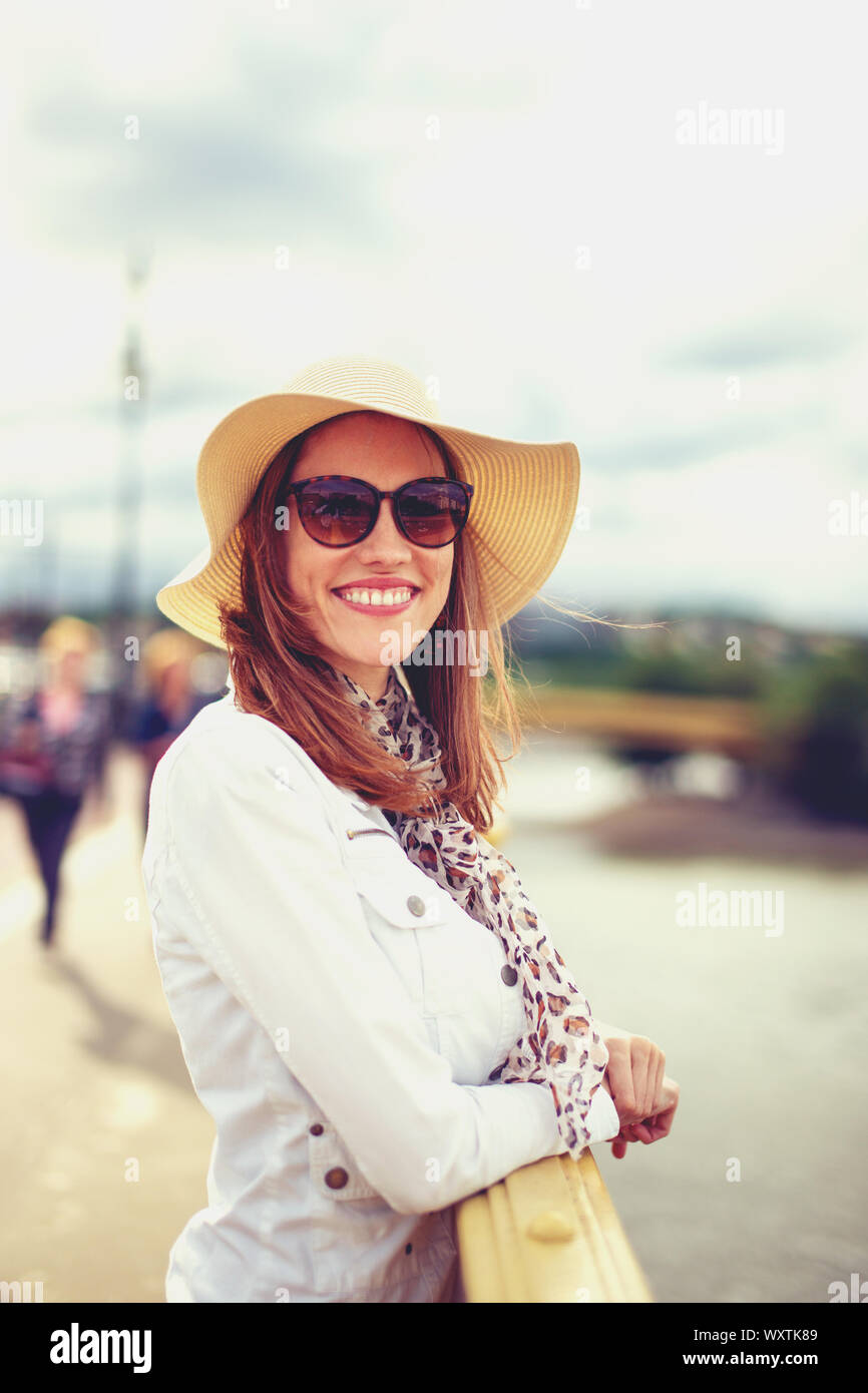 Happy young woman in hat tendance sur le sourire à pleines dents et looking at camera Banque D'Images