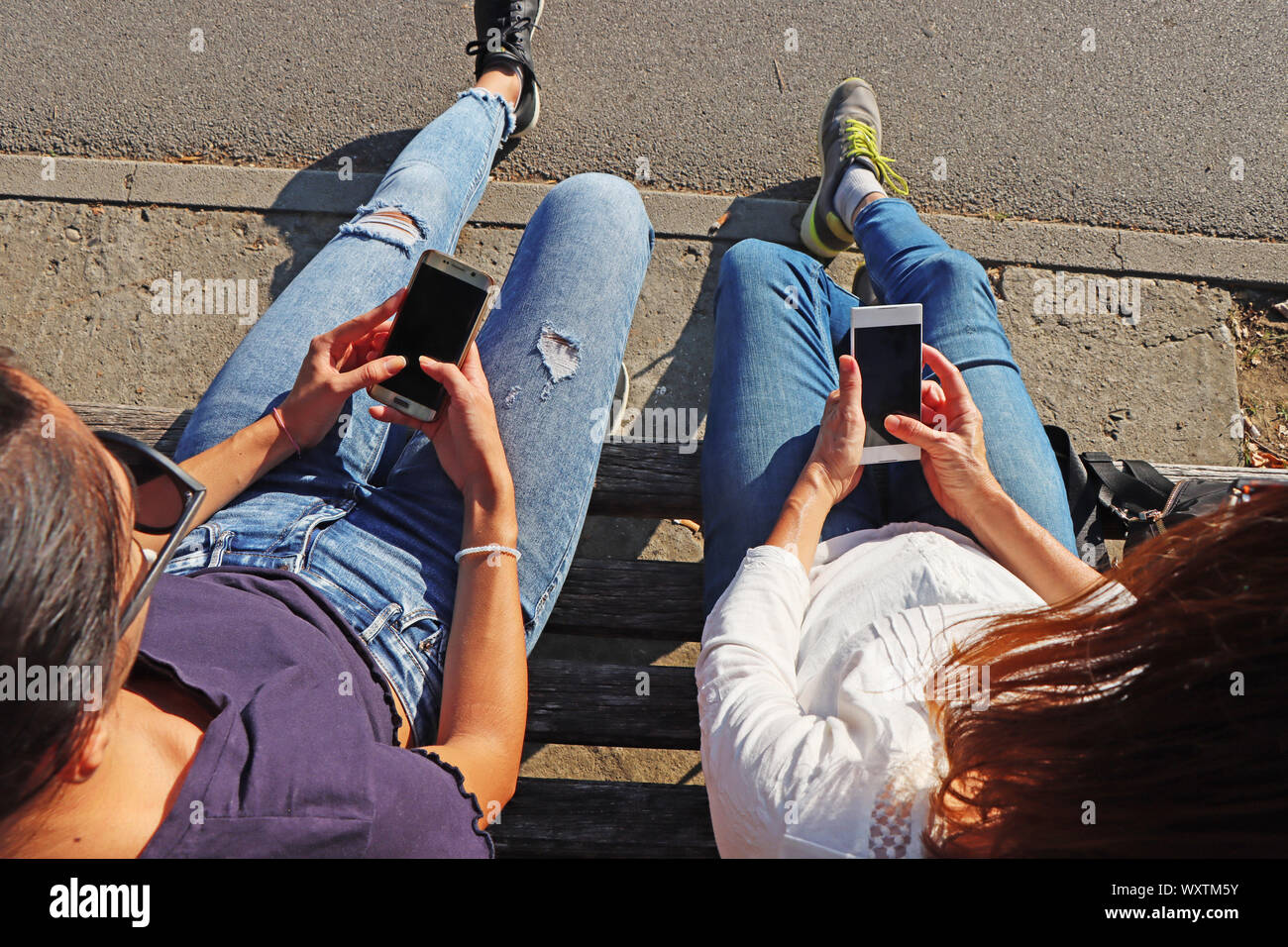 Deux jeunes filles en regardant des téléphones mobiles Banque D'Images