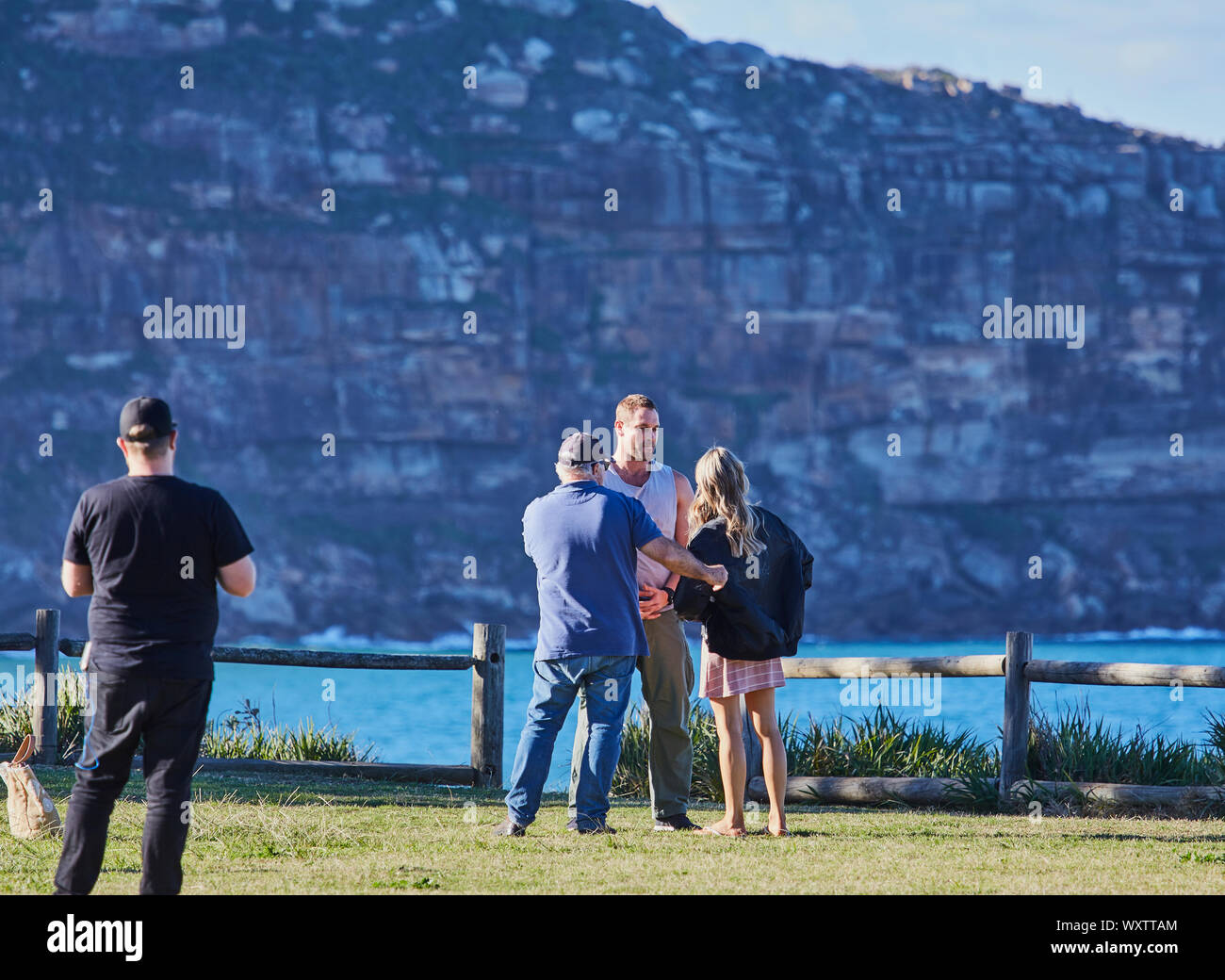 Acteurs Jake Ryan, Sam Frost et les membres de l'équipage de se préparer à une scène en plein air du film Home & Away séries télé au Palm Beach, Australie Banque D'Images