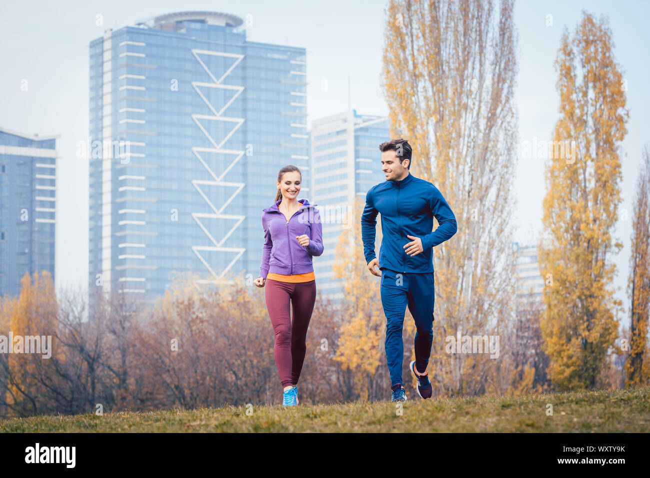 Jogging urbain - couple en marche en automne ville sur une colline Banque D'Images
